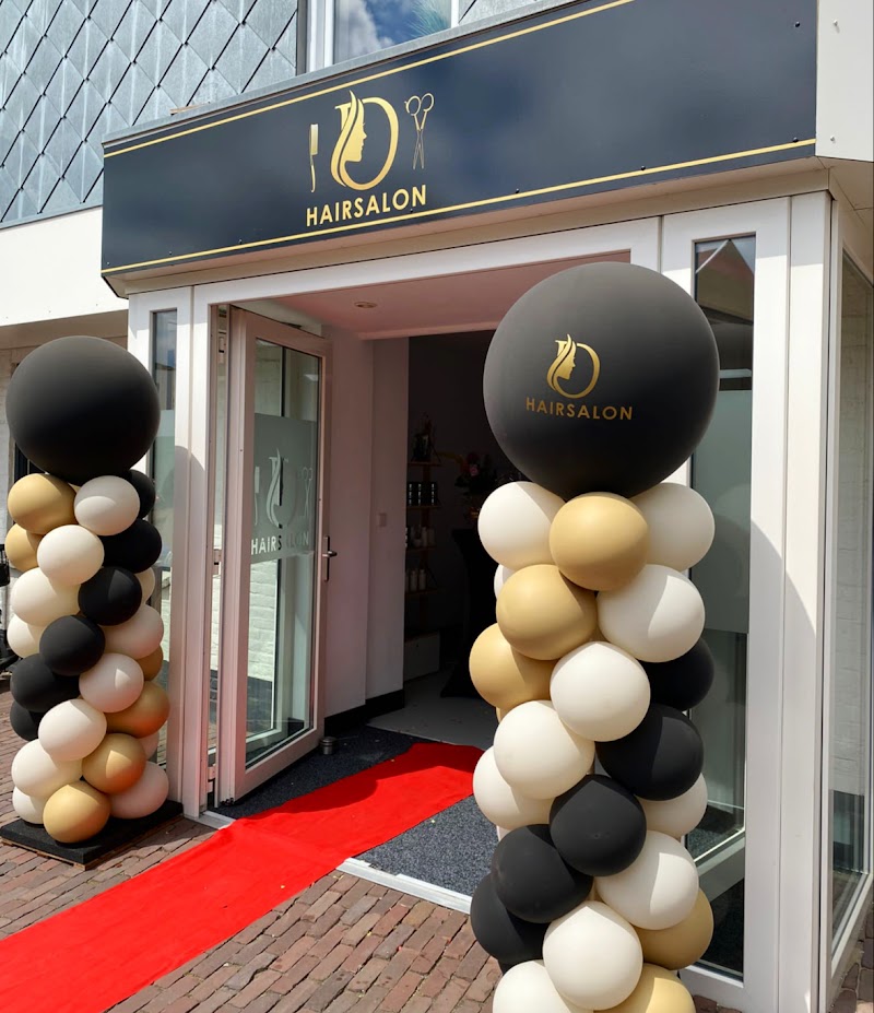 De zwarte gevel van D Hairsalon aan de Varkensmarkt in Raalte, met gouden letters en ballonnen op de openingsdag.